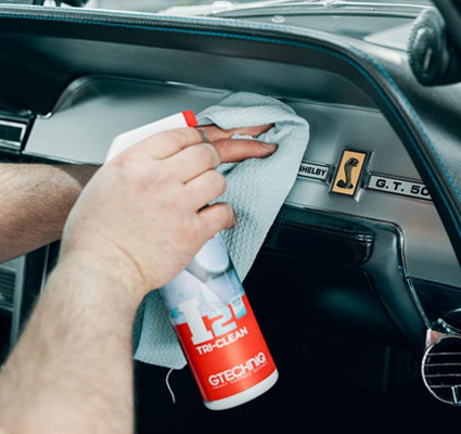 Interior panel of a vehicle being wiped down with a cleaning cloth during detailing.