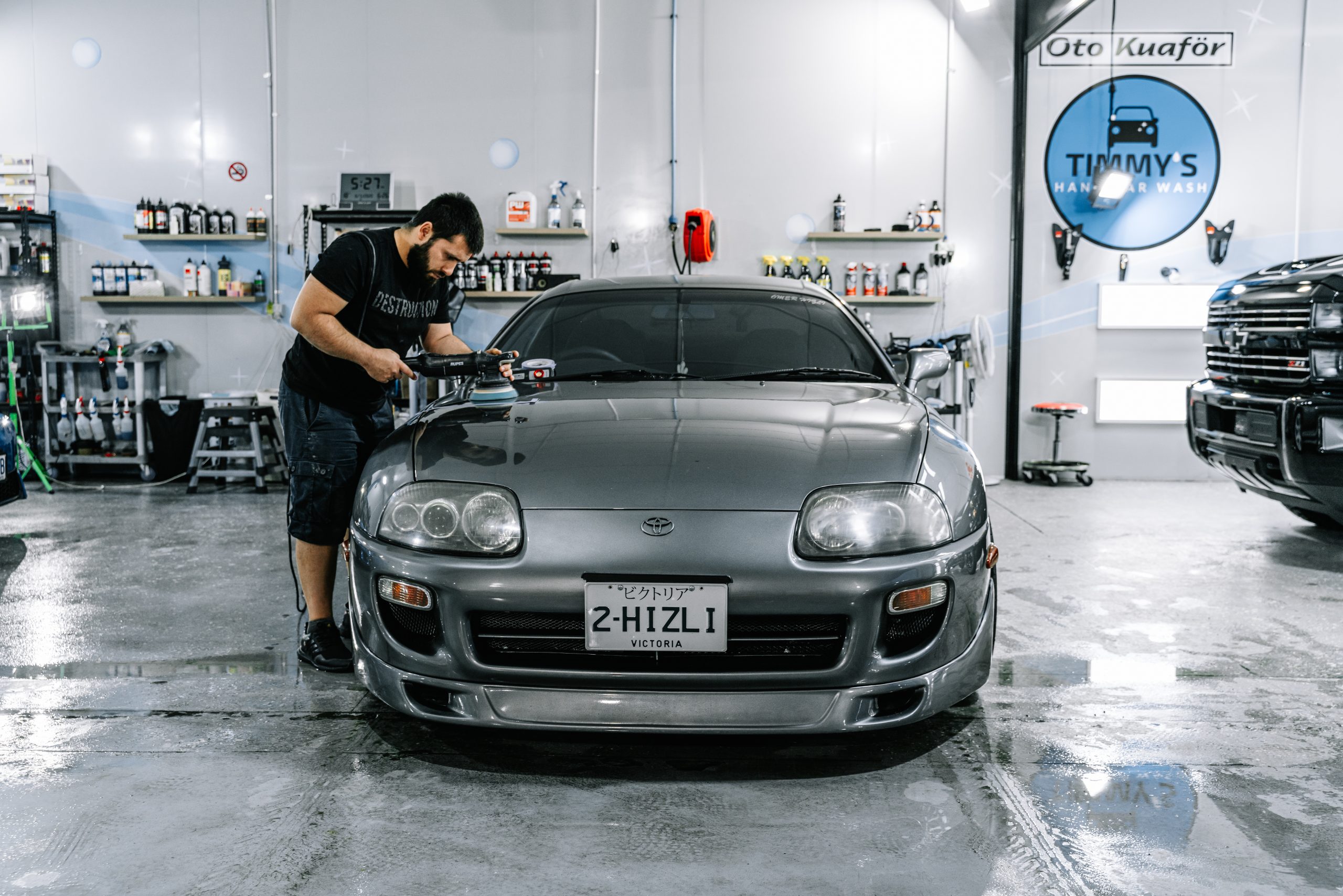 oyota Supra undergoing paint correction, with visible improvements to the vehicle’s paintwork, showcasing a smoother and more refined finish