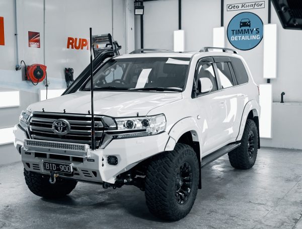 White Toyota 4x4 in a showroom setting, showcasing its meticulously detailed and spotless exterior.