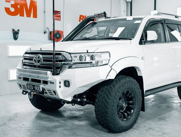 White Toyota 4x4 in a showroom setting, showcasing its meticulously detailed and spotless exterior.